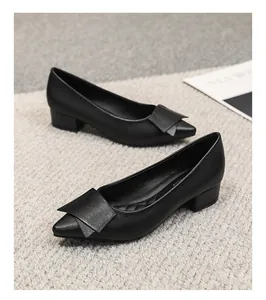 Détail rapproché d'élégants escarpins noirs à bout pointu avec nœud décoratif pour femme