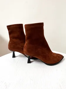 Seitenansicht eleganter brauner Stretch-Stiefeletten aus Wildleder mit Pfennigabsatz