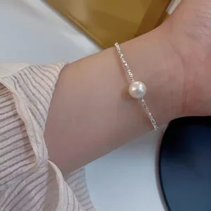 Elegant minimalist silver-tone chain bracelet with a single white pearl on wrist