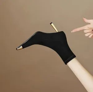 Detailed view of black stretch stiletto boot with gold metallic square toe and heel