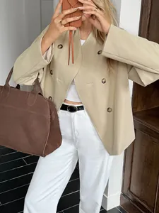 Detailed macro view of women's beige double-breasted blazer featuring tortoise buttons