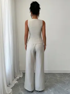 Vista posteriore di un set gilet beige senza maniche e pantaloni a gamba larga.