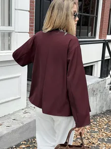 Rear view of an elegant burgundy long-sleeve blazer jacket for women in urban setting