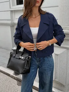 Detailed close-up view of a navy blue cropped jacket paired with classic blue denim jeans.