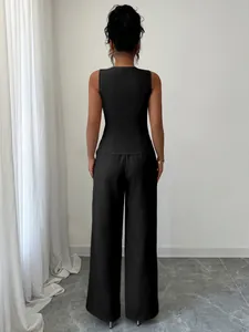 Vista posteriore di un elegante set gilet nero senza maniche e pantaloni larghi da donna.