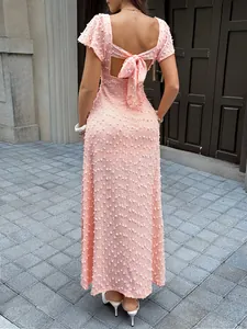 Détail de la vue arrière d'une robe longue en jacquard rose avec un nœud papillon chic
