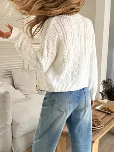 Rear view detail showing intricate braided patterns of a white cable-knit cardigan