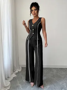 Dettaglio completo gilet nero e pantaloni larghi con profili bianchi a contrasto