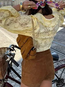 Detail shot of a pale yellow French vintage lace blouse with delicate floral patterns