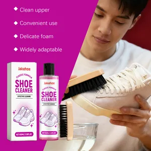 Close-up view of Jakehoe shoe cleaner kit used on white sneakers by a person