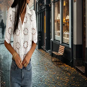 Gros plan d'un chemisier blanc à manches courtes avec broderie anglaise et dentelle fine