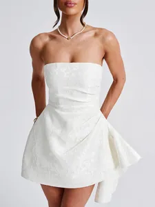 Detail view of a white strapless jacquard mini dress with elegant floral texture.