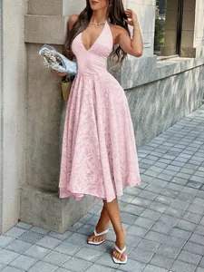 Model posing outdoors wearing a light pink floral jacquard midi dress with deep V-neckline