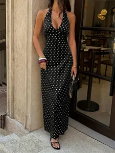 Detailed view of a black polka dot halter maxi dress featuring a deep V-neckline and open back