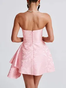 Back view detail of a pink floral jacquard tube dress with asymmetric ruffle hem.