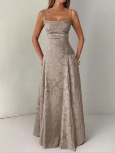 Detailed view of elegant champagne floral maxi dress with thin straps on model for resort