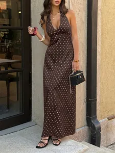Full length detail of a brown polka dot halter maxi dress featuring a sexy deep V-neckline