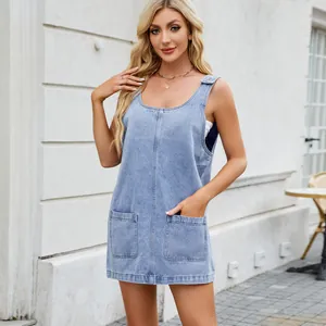 Chic light blue washed denim pinafore dress featuring front pockets and wide shoulder straps