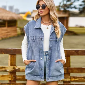 Vista dettagliata di un gilet in denim lavato chiaro con grandi tasche all'aperto.