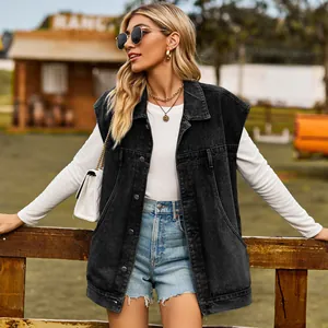 Dettaglio di un gilet in denim nero lavato oversize con ampie tasche laterali