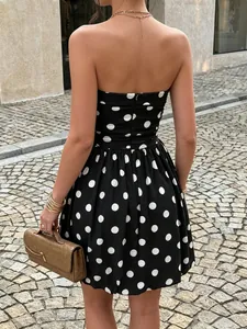 Detail shot of a vintage black and white polka dot strapless dress with a back zipper.