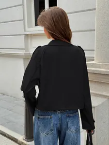 Rear view showing the fit of a stylish black long-sleeve jacket for women in urban setting