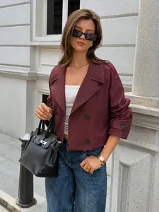 Model wearing a cropped burgundy double-breasted jacket with blue jeans outdoors