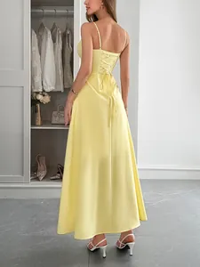 Detail of yellow backless maxi dress featuring elegant lace-up back design