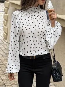 Close-up of elegant white polka dot mock neck puff sleeve shirt for a chic summer look