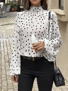 Close-up of elegant white polka dot blouse featuring mock neck and stylish puff sleeves