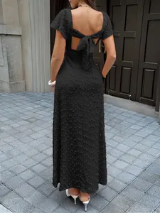 Détail d'une robe longue en jacquard noir avec élégant nœud au dos et découpe