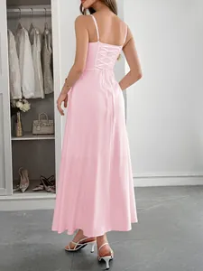 Detail view of the back of a pink camisole maxi dress with an elegant lace-up design