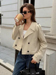 Side profile of a stylish beige cropped trench jacket worn in an urban street setting