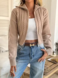 Detail of a beige cable-knit zip-up cardigan sweater with French resort style charm.