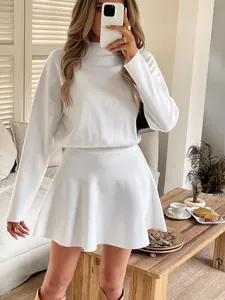 Detailed view of white knit fabric texture on long-sleeve flared skirt mini dress