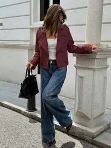 Women's chic burgundy short trench jacket paired with wide-leg jeans in street style