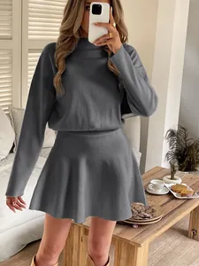 Close-up of grey long-sleeve knitted mini dress in a cozy indoor mirror selfie setting
