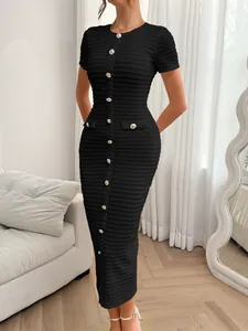 Detail of textured knit fabric and decorative buttons on a slim-fit black short-sleeved dress