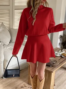 A stylish red long-sleeved knitted mini dress presented in a cozy indoor lifestyle setting.