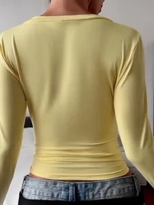 Back view detail showing the slim fit of a yellow long-sleeve elegant T-shirt for women