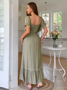 Detailed back view of a green short-sleeve maxi dress with white ruffle trim in vacation style