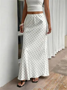 Détail d'une jupe midi en satin blanc crème à motif de pois noirs élégante
