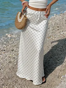 Jupe midi élégante en satin blanc crème à pois dans un cadre de vie idéal à la plage.