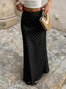 Gros plan sur une élégante jupe midi en satin noir à pois blancs pour les tenues d'été