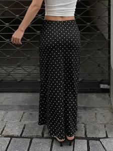 Détail de la vue arrière d'une jupe mi-longue en satin noir à pois blancs élégante.