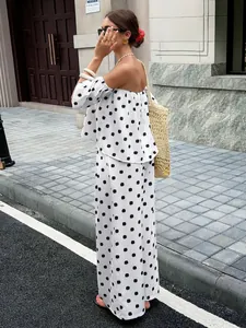 Detaillierte Ansicht des schulterfreien Polka-Dot-Oberteils und der passenden Hose in Weiß