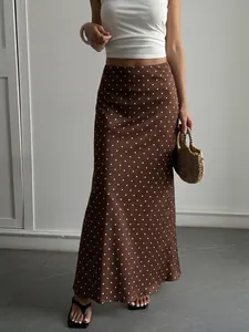 Vue détaillée d'une jupe midi en satin marron à pois blancs et texture soyeuse