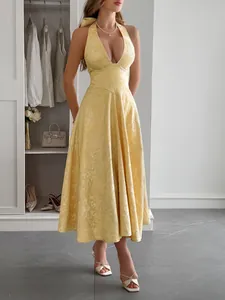 Élégante robe longue jaune à licou avec un tissu texturé et une taille très cintrée