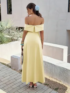 Back view of an elegant yellow off-shoulder maxi dress worn by a model outdoors