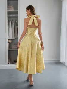 Vue arrière d'une robe licou en jacquard jaune avec un grand nœud et un corset lacé